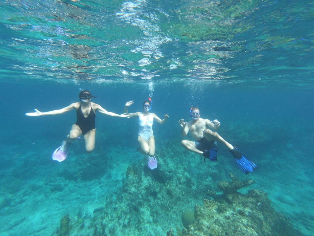 Guests on a Private Snorkeling Tour in Turks and Caicos Three guests snorkeling over a coral reef in clear turquoise water on a private Turks and Caicos snorkeling charter from Providenciales